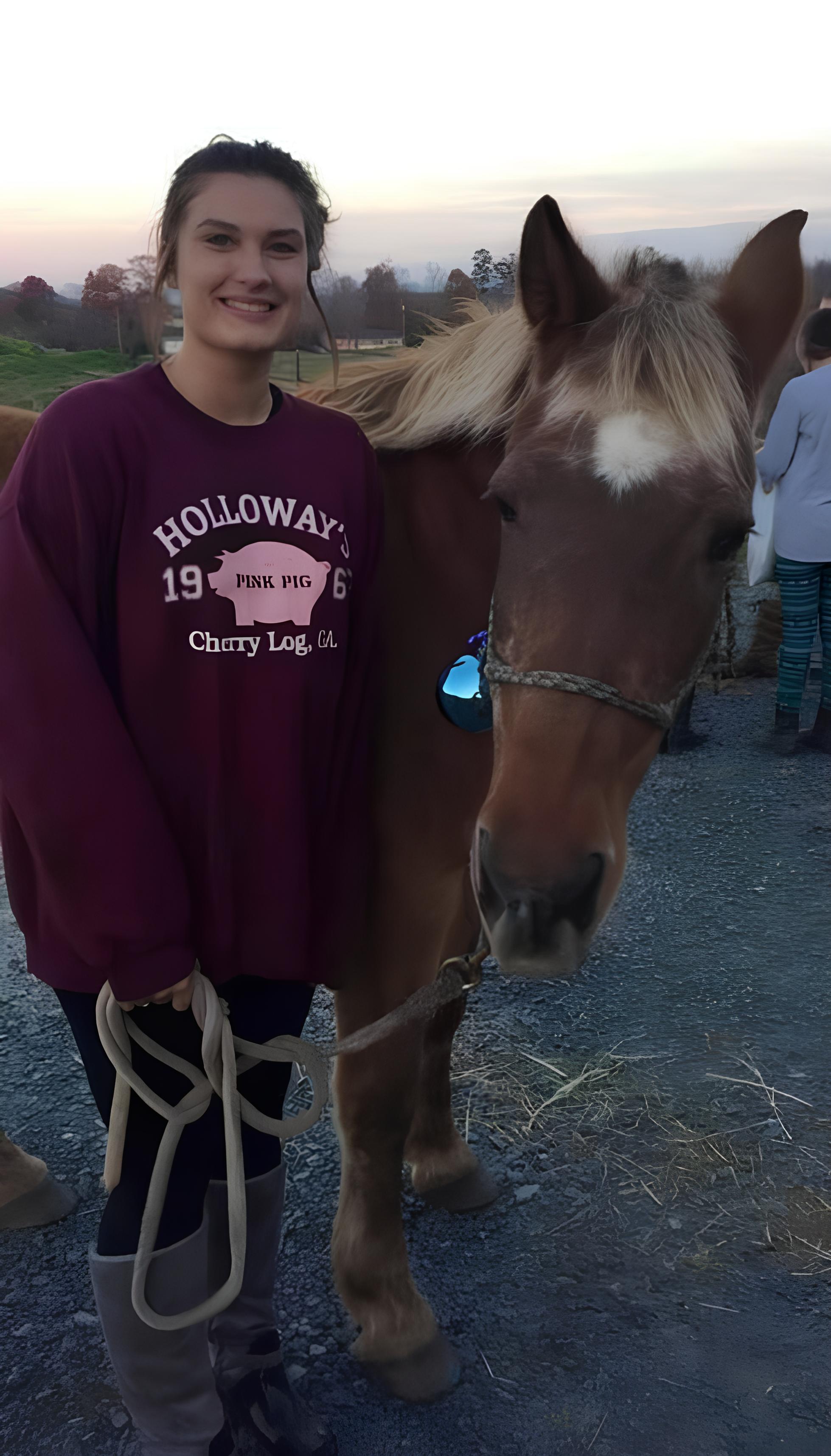 Lexi Lewis, barn manager of AEA, with a brown horse
